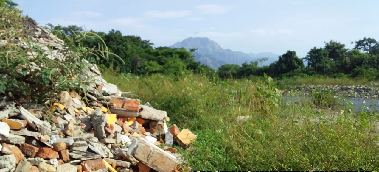 Escombros de ladrillo y piedras en la margen del río Guatapurí