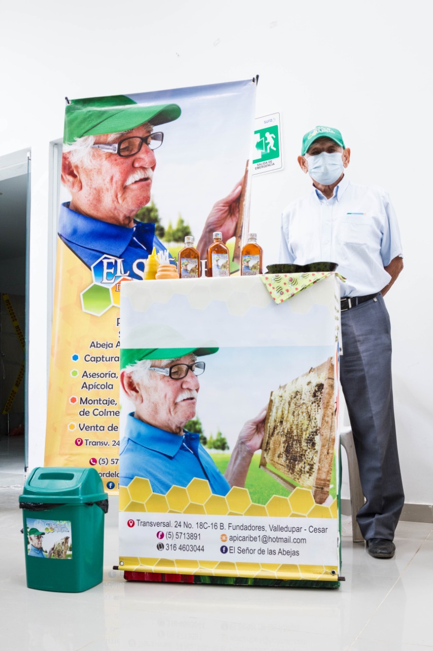 Un funcionario junto a un puesto con productos de un emprendimiento de Negocios Verdes