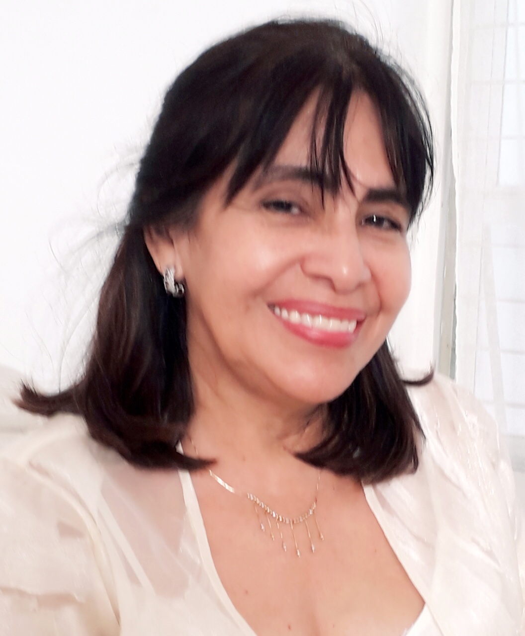 Retrato de una mujer sonriente con cabello oscuro y blusa clara