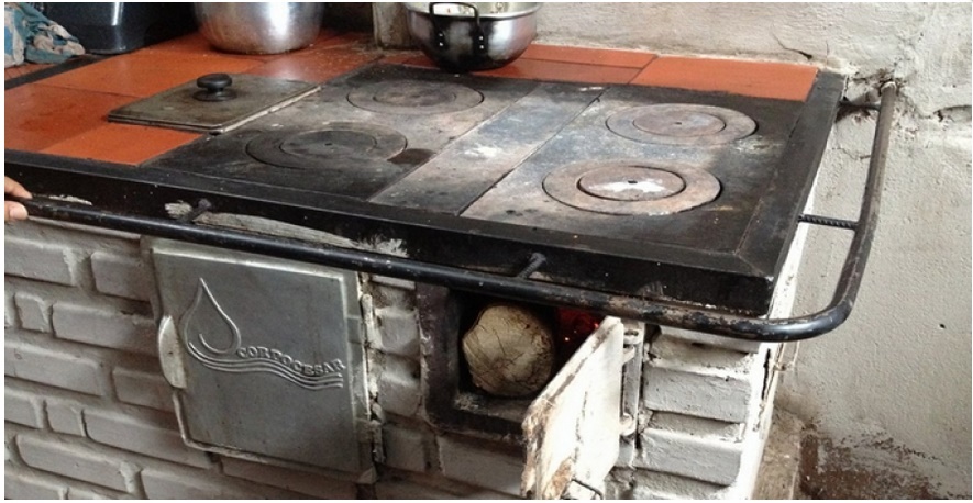 Estufa de leña ecoeficiente de ladrillo y hierro con la marca Corpocesar en la puerta del horno