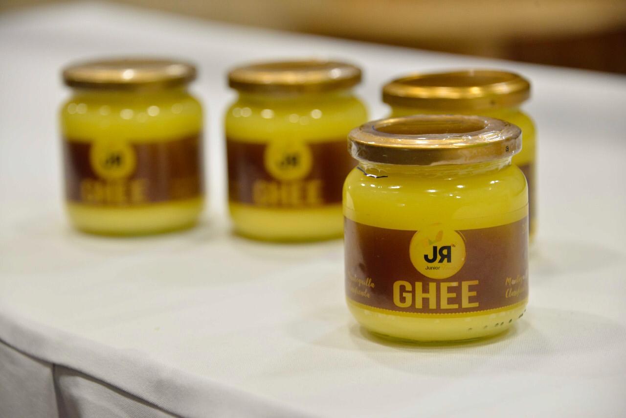 Tres frascos de ghee con la etiqueta «JR Ghee» sobre una mesa.