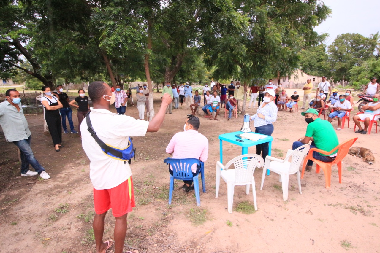 Un hombre se dirige a la comunidad reunida bajo los árboles en Guacochito