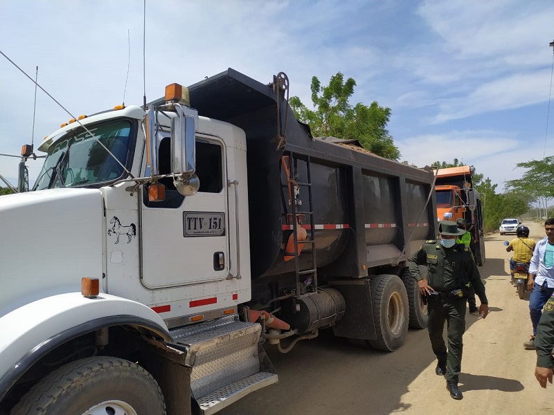 Un camión volqueta de carga y un policía en una vía de la vereda El Cielo