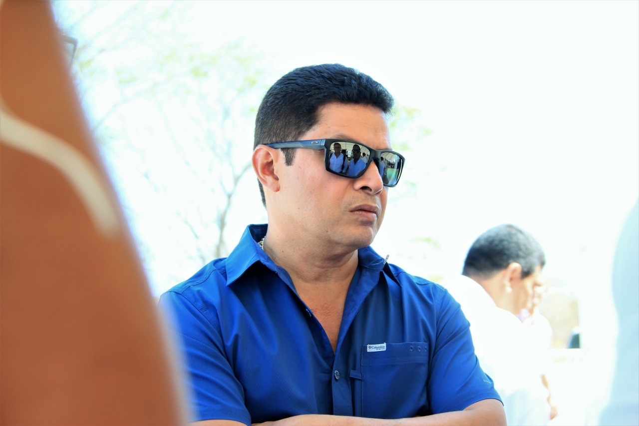 Retrato de un hombre con gafas oscuras y camisa azul
