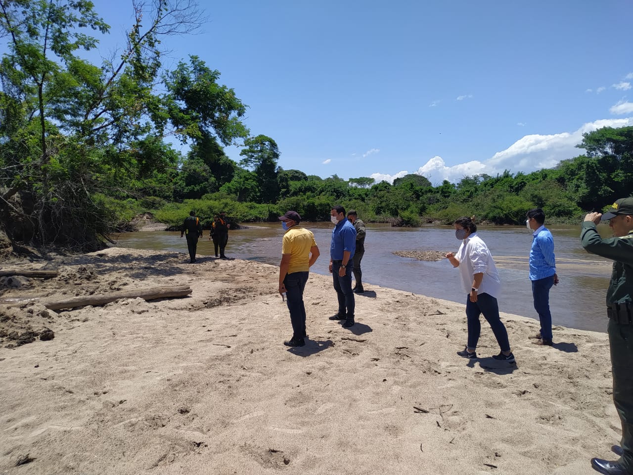Funcionarios caminan por una playa de arena a orillas del río Cesar
